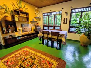 une salle à manger avec une table et un sol vert dans l'établissement Villa Alma, à Ahangama 23 autres photos