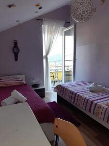 a bedroom with two beds and a window with a view at Apartments Flower house in Bribir