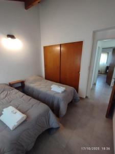 a room with three beds and a wooden cabinet at Casa Paso in Puerto Madryn +1 photo