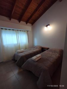 玛德琳港Casa Paso的一间卧室设有两张床,其中设有窗户。