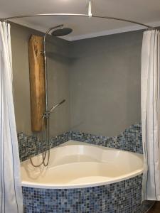 eine Badewanne mit Dusche im Bad in der Unterkunft Zum alten Rittergut in Malschwitz + 11 Fotos
