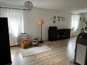a living room with a wooden floor and a lamp at Zum alten Rittergut in Malschwitz