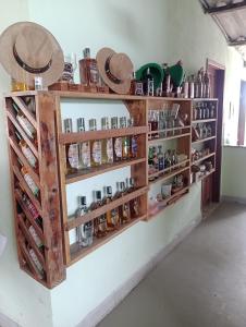 Pousada Nosso Cantinho في غواراباري: رف مليء بالكثير من الزجاجات على الحائط
