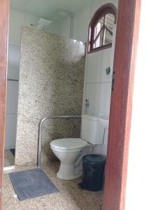 Pousada Nosso Cantinho في غواراباري: حمام مع مرحاض أبيض ومغسلة