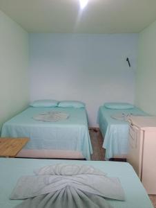 Pousada Nosso Cantinho في غواراباري: غرفة بها سريرين في غرفة