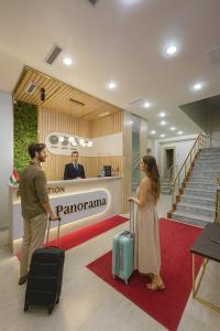 a man and a woman with luggage in a lobby at Panorama Hotel & More in Samarkand +24 photos