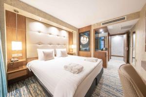 Una habitación de hotel con una cama grande y un baño. en Grand Canyon Hotel, en Ankara
