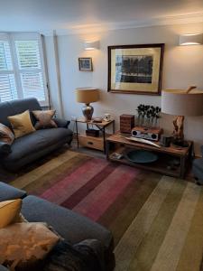 a living room with a couch and a table at Havisham House in Woburn