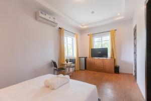 une chambre avec un lit et une télévision à écran plat dans l'établissement The Strype Hotel Tagaytay, à Tagaytay