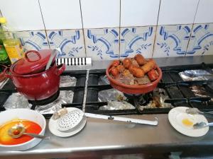 a stove top with a pot of food and a bowl of food at Hostería Casa Flor in Murias de Rechivaldo +32 photos