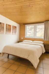 Un dormitorio con una cama grande con dos ventanas. en Hostal Yeti, en Sierra Nevada