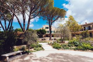 a park with a bench and trees in front of a building at Auberge du Rédier - Logis Hôtels in Colomars +45 photos