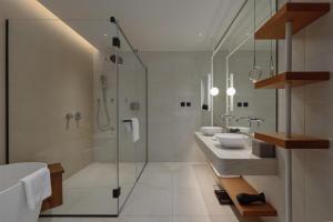 a white bathroom with two sinks and a shower at SIRO Boka Place in Tivat