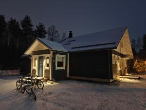 une maison avec des vélos garés à l'extérieur la nuit dans l'établissement Villa in Lehtikangas, à Rovaniemi