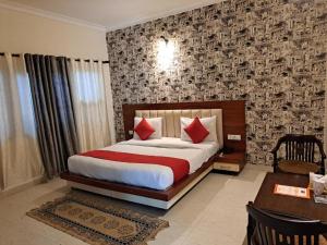 a bedroom with a bed with red pillows and a table at Airport Hotel Port View,Complimentary Airport Pickup or Drop in New Delhi
