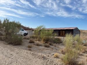 a car parked in front of a house in the desert at Escapada rural con sauna y relax en la naturaleza in Níjar
