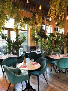 a restaurant with tables and chairs and plants at Aiden by Best Western Lorient Centre in Lorient +38 photos