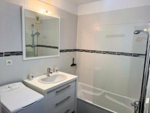 a white bathroom with a sink and a shower at Rétro - Parking - Wifi - Centre in Dax