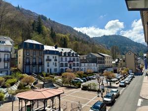 a town with cars parked in a parking lot at La Bonbonnière Centre ville - Thermes - Netflix in Mont-Dore