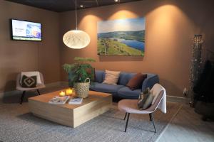 a living room with a blue couch and a table at Hotell Klövsjöfjäll in Klövsjö