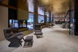 a lobby with chairs and tables in a building at Berghotel in Racines