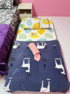 a bed with a blue blanket on top of it at Amani guesthouse in Padang Besar +3 photos