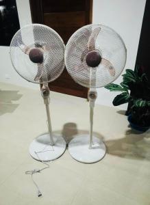 a couple of white fans sitting on top of a floor at Tiwi's Travellers Inn in Puerto Princesa City