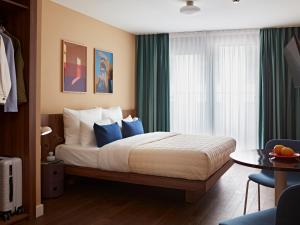 a bedroom with a large bed with blue pillows at Numa Stuttgart Rotebühlplatz in Stuttgart