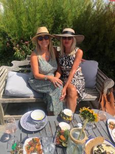 twee vrouwen zitten op een bankje met een tafel vol eten bij Num 29 in Newquay