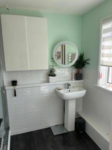 een witte badkamer met een wastafel en een spiegel bij Num 29 in Newquay