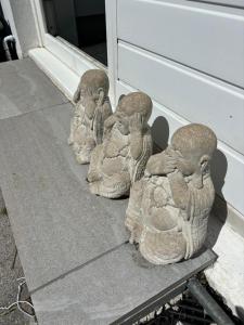 Un grupo de pájaros de piedra sentados junto a una puerta. en Num 29, en Newquay