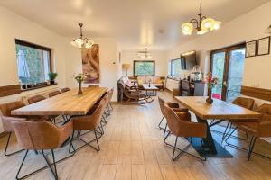 a living room with wooden tables and chairs at Cazare Colibița Casa Lipan cu jacuzzi, foișor și loc de joacă in Colibiţa
