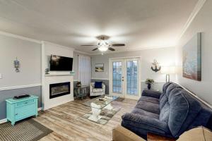 un salon avec un canapé bleu et une télévision dans l'établissement Colony Club Condos, à Gulf Shores 40 autres photos