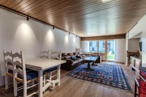 a living room with a table and a couch at Prada Laax by Quokka 360 - building with sauna in Laax