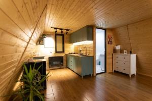 a kitchen with green cabinets and a wooden ceiling at Wood Side in Tʼerjola