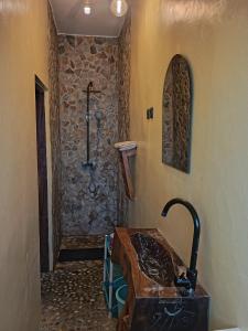 a bathroom with a sink and a stone wall at Le Hublot in Cotonou