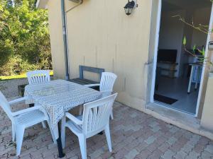 a white table and chairs on a patio at studio indépendant in Salles-la-Source