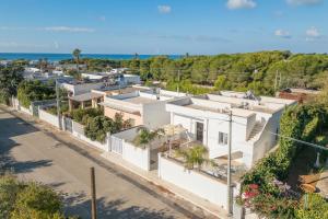 an aerial view of a white house with the ocean in the background at Mirèa - Lux Coastal Villa in Torre Lapillo