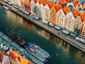 an aerial view of a river with buildings and a boat at DEO PLAZA Apartments & Riverside by Downtown Apartments in Gdańsk