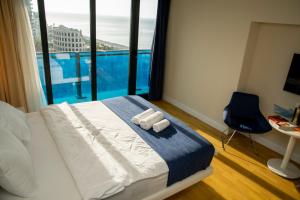 a bedroom with a bed with two towels on it at Sunny Sea View Aparthotel in Orbi City Batumi in Batumi