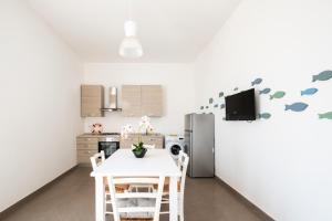 une cuisine avec une table et un réfrigérateur dans l'établissement Arvèa – Lux Coastal Essence, à Torre Lapillo 23 autres photos