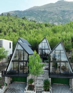 a group of glass homes with mountains in the background at Lakeside Villas in Široka +29 photos