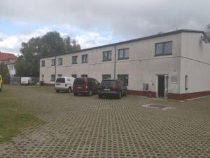 un bâtiment avec deux voitures garées dans un parking dans l'établissement Einzelzimmer mit Bad HG 3, à Zwickau