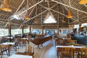 a restaurant with tables and chairs and a boat on the ceiling at White Paradise Zanzibar in Pongwe