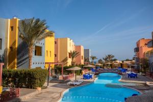 a resort with a swimming pool and palm trees and buildings at Al Dora Resort Hurghada in Hurghada