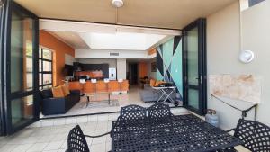 a living room with a couch and a table and chairs at Luxury Beachfront Penthouse Umdloti in Umdloti