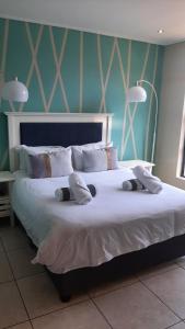 a large bed with white sheets and pillows at Luxury Beachfront Penthouse Umdloti in Umdloti