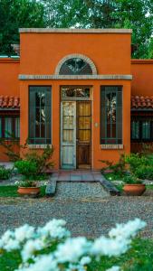 an orange house with a door in front of it at Finca La Saucina Casa de Campo in Tunuyán