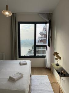 a bedroom with a bed and a large window at Belgrade Waterfront Sky & River View Residences in Belgrade