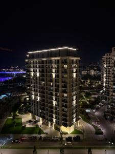 a night view of a large building with lights on at Belgrade Waterfront Sky & River View Residences in Belgrade
